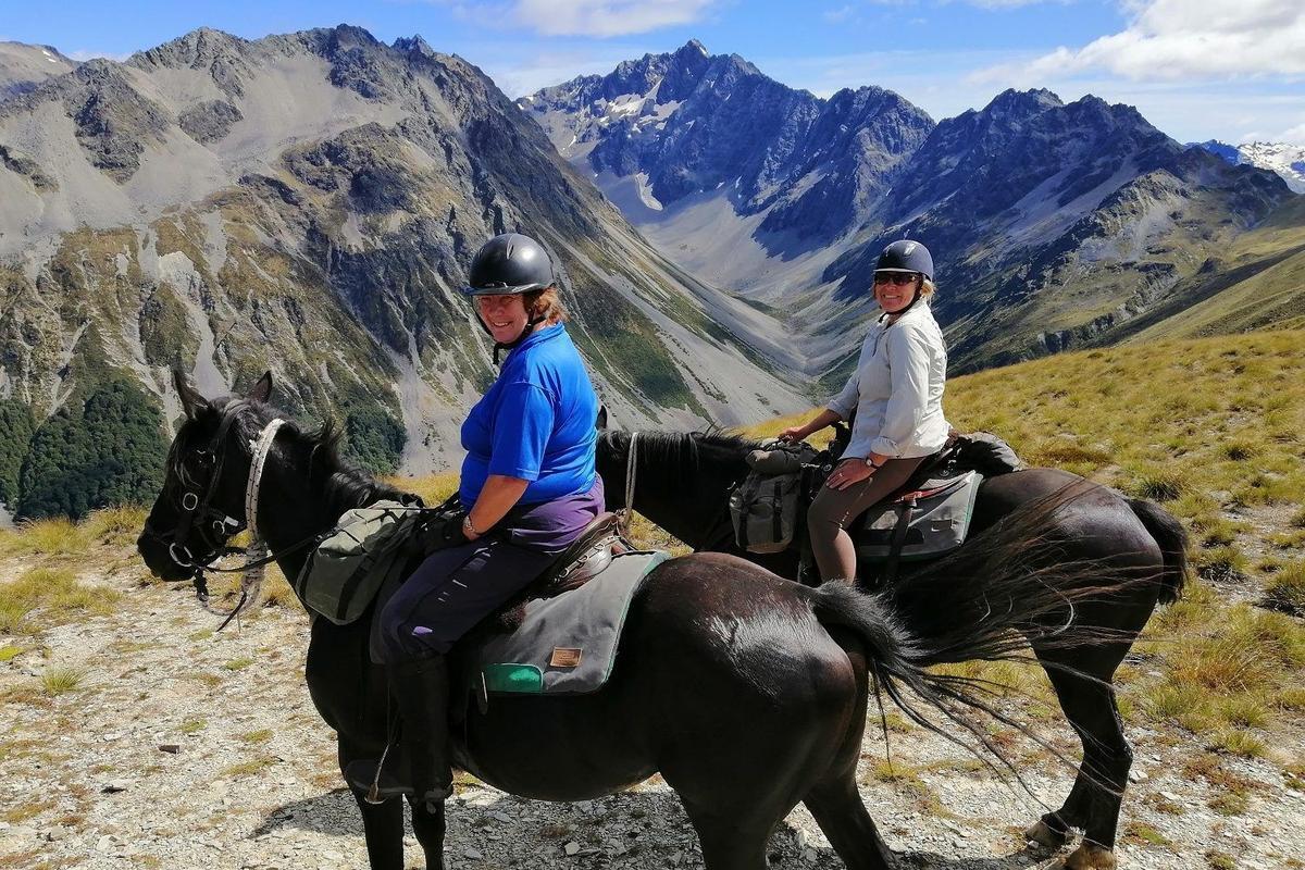 Tourists riding horses in the mountains of New Zealand