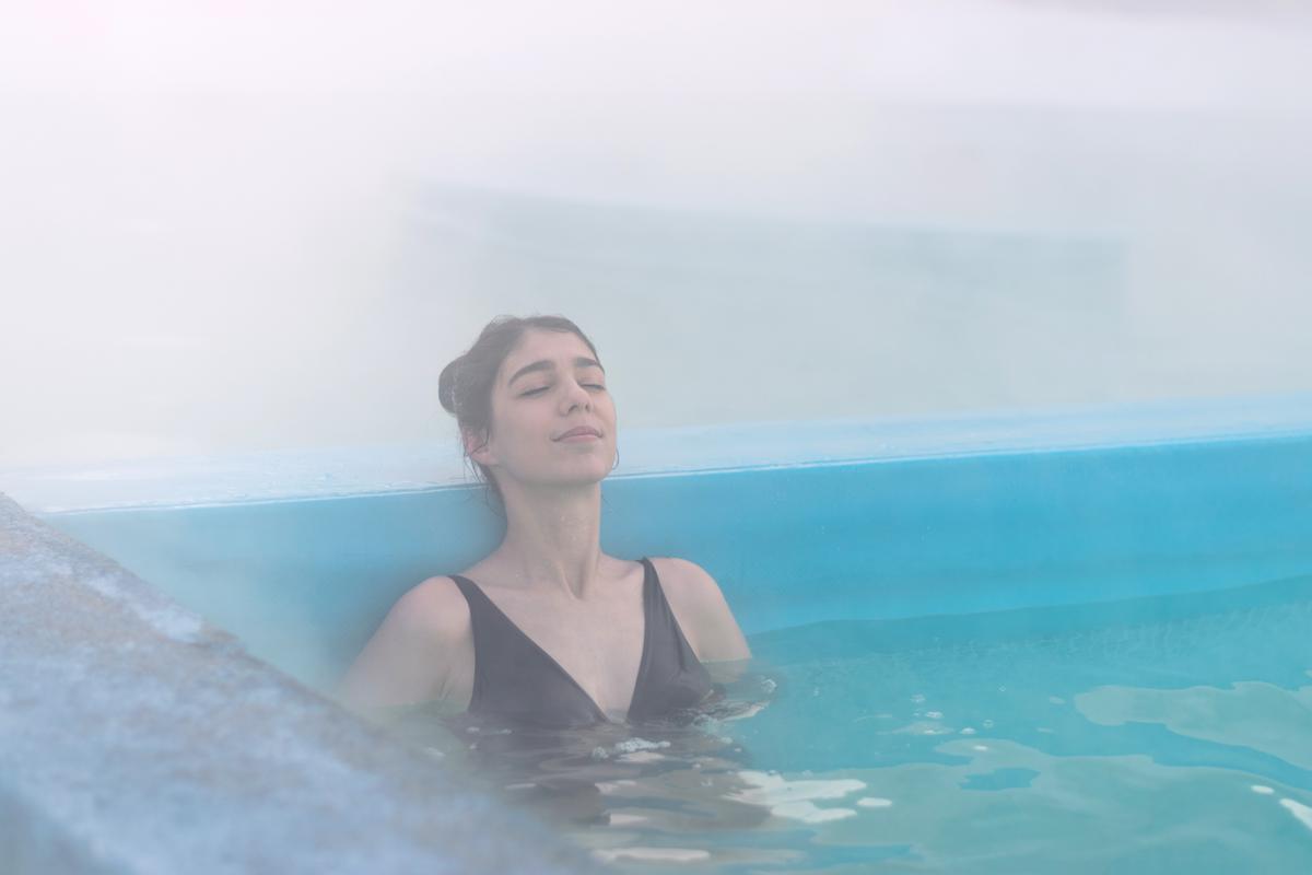 Девушка в бассейне с термальной водой зимой