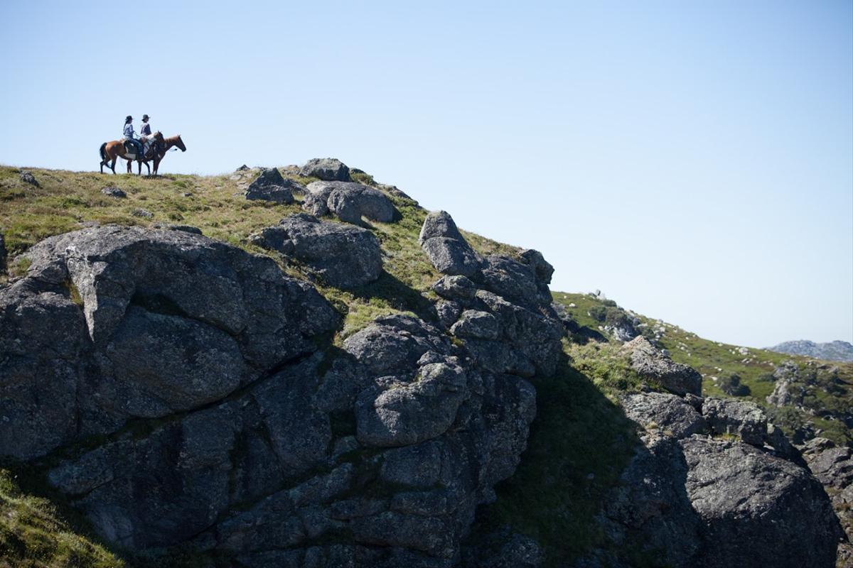 People riding a horse in the Australian mountains