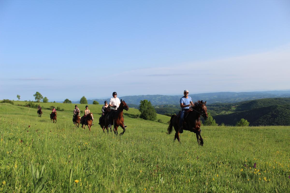 Tourists on horseback gallop across the expanses of Serbia
