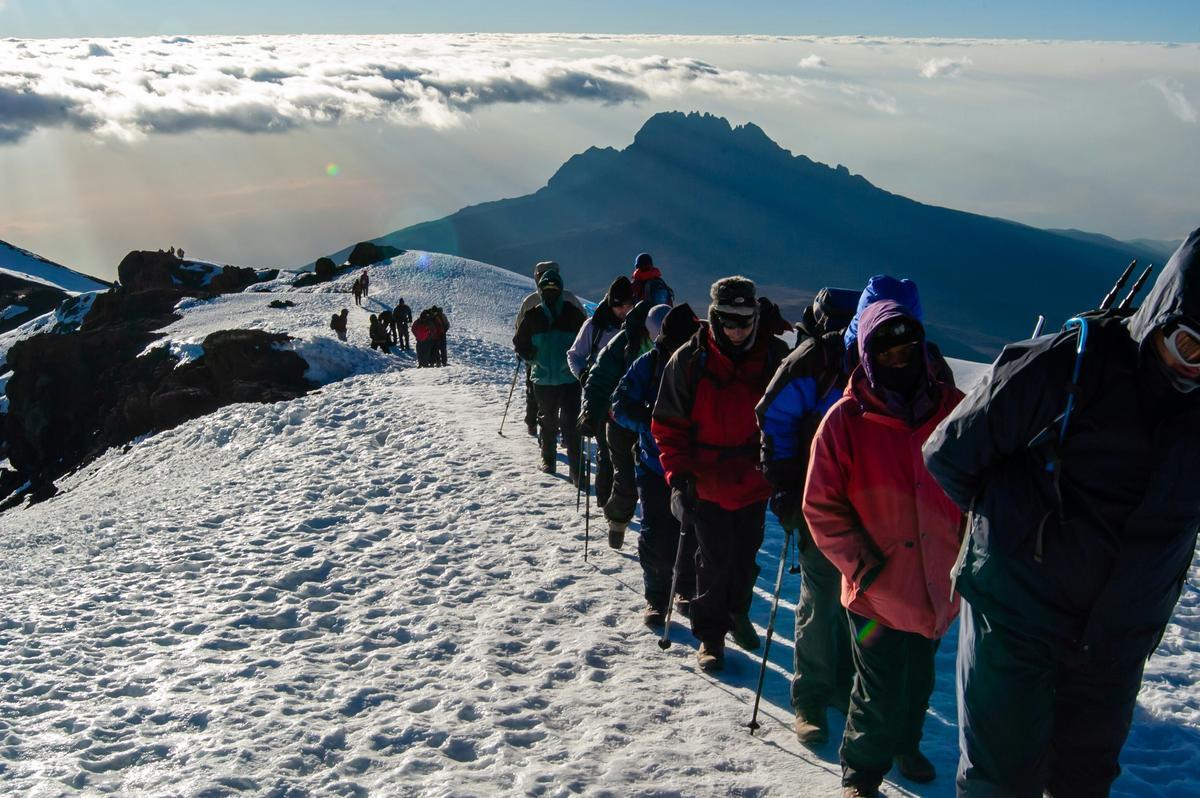 A group of tourists climb Mount Kilimanjaro