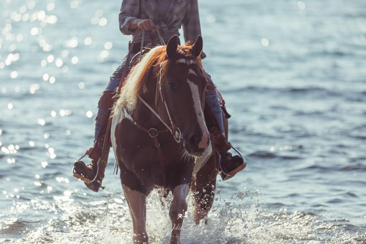 A girl riding a horse on the beautiful beach of Punta Ala