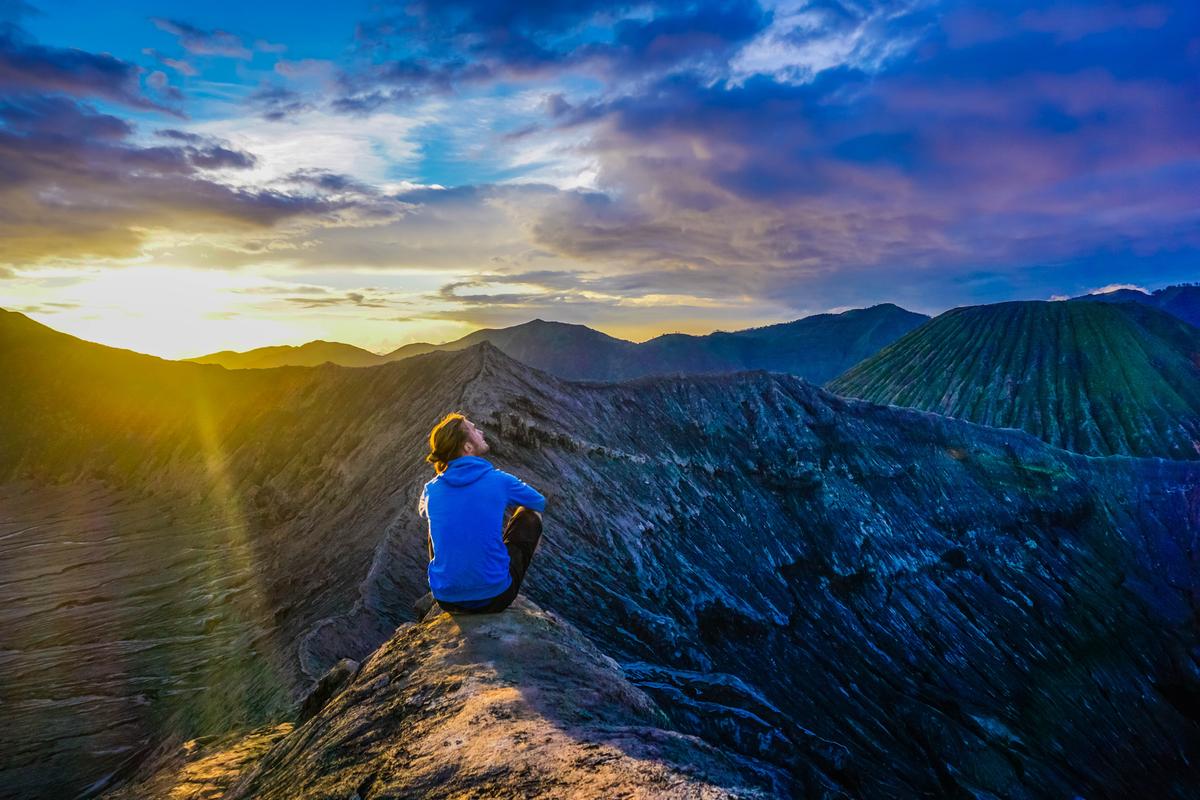 Турист на хребте вулкана Бромо на закате